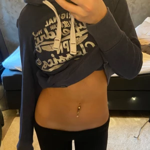 Blå hoodie från Superdry - Säljer en snygg blå hoodie från Superdry med tryck framtill. Den har en justerbar huva med vita snören och en praktisk magficka. Perfekt för en avslappnad stil. Hör av dig vid intresse! 💙Väldigt gammal men oanvänd så finns inte kvar på marknaden. Hoodien är väldigt liten i storlek så den skulle passa någon som har xs/s i storlek även om den egentligen är en medium. Väldigt snygg och välsittande, med tjockt tyg som håller en varm 