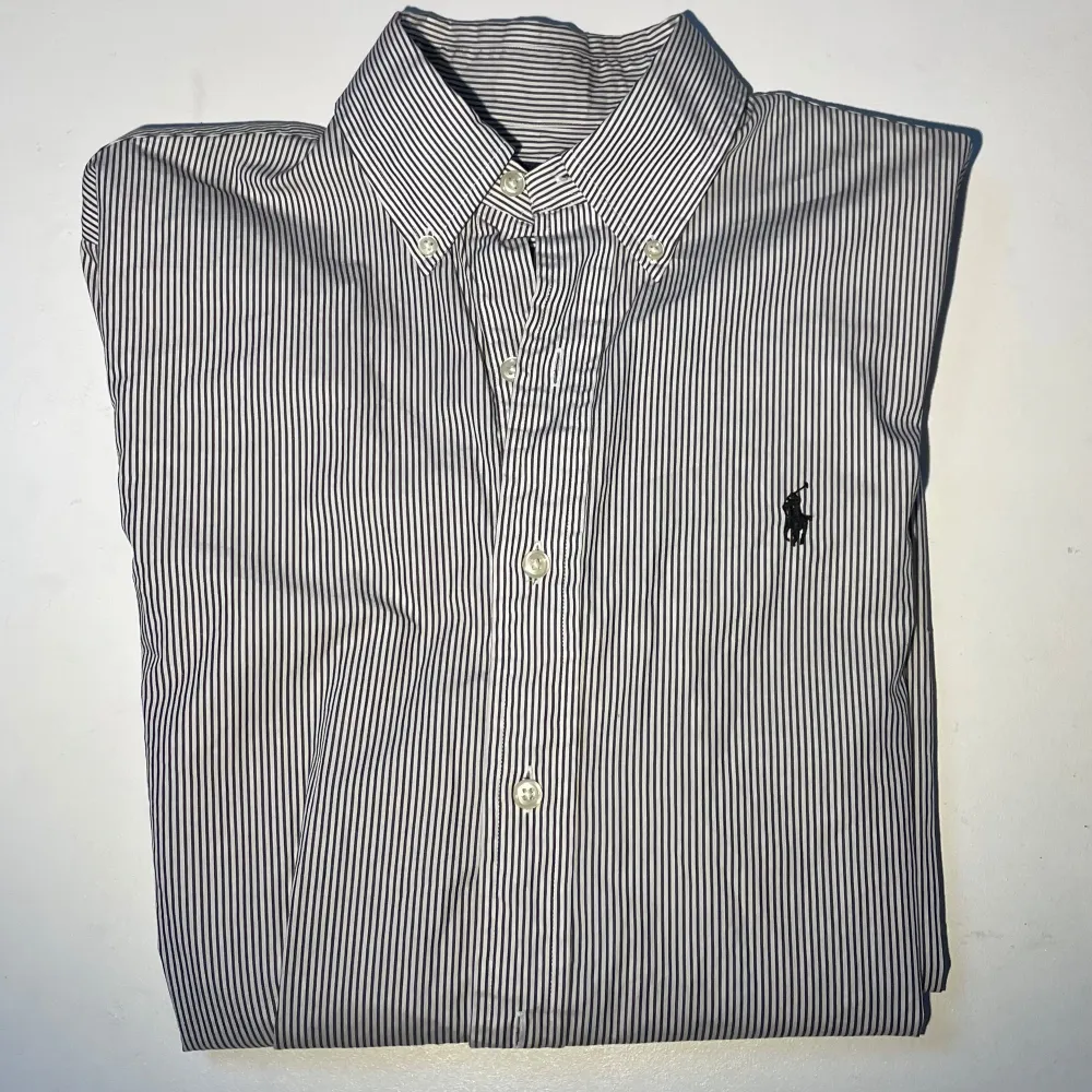 Säljer nu denna snygga Ralph Lauren skjorta som är vit/mörkblå randig. Mycket bra skick utan några defekter! Hör av dig om du undrar något!. Paidat.