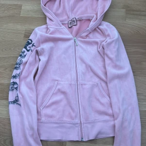 Zipup från Juicy Couture - Säljer denna skitsnygga tröjan från Juicy Couture. Den har ett tryck på ryggen och ena ärmen. Jättebra skick och sitter väldigt fint. Passar xs-s.
