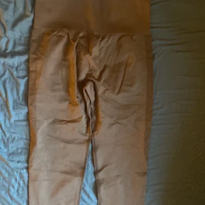 Bruna leggings i polyamid - Säljer ett par bruna leggings i stretchigt material med hög midja. Tillverkade av 92% polyamid och 8% elastan, vilket ger en bekväm och flexibel passform. Perfekta för en avslappnad stil eller träning.