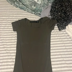 Grön klänning från The Black Label Collection - Säljer en stilren grön klänning från The Black Label Collection. Klänningen har korta ärmar och en enkel design som gör den lätt att matcha med olika accessoarer. Perfekt för en minimalistisk look.