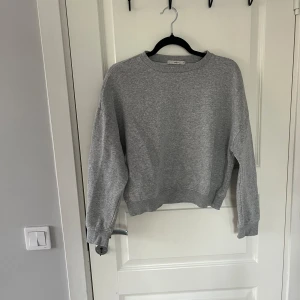 Grå sweatshirt från Pigalle - Säljer en stilren grå sweatshirt från Pigalle i storlek XS. Tröjan har en klassisk rund halsringning och långa ärmar. Perfekt för en avslappnad look.