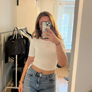 Tshirt NA-KD - Vit T-shirt med dragsko på båda sidor så längden går att justera. Aldrig använd och sååå mjuk!