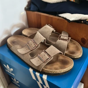 Bruna sandaler från Pier One i 43 - Säljer ett par bekväma bruna sandaler från Pier One. De har dubbla remmar med justerbara spännen och en ergonomisk fotbädd för extra komfort. Perfekta för varma dagar. 