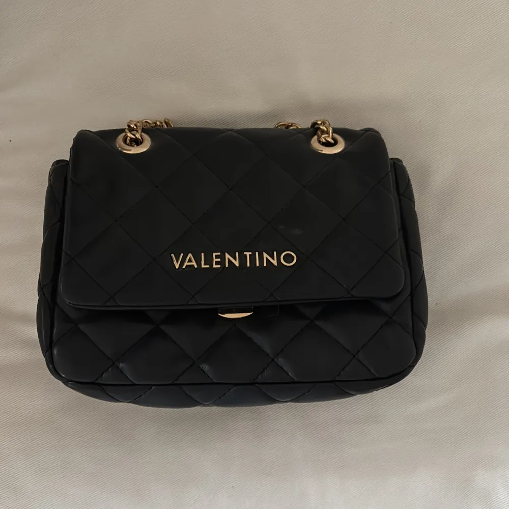 svart axelväska från Valentino med quiltad design och guldfärgade kedjedetaljer. Kedjan går både att ha lång och kort och ett väldigt fint skick.. Laukut & Käsilaukut.