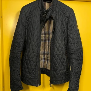 Jacka Belstaff - Mörkblå Belstaff-jacka säljes, herr strl 52. Det finns ett mindre hål (se bild) på höger arm, fint skick i övrigt!