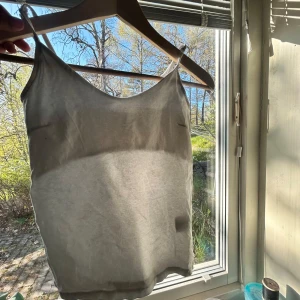 Vit linnetopp med smala axelband - Säljer en enkel och stilren vit linnetopp med smala axelband. Perfekt för varma dagar och lätt att matcha med olika outfits. Tunn och luftig känsla.