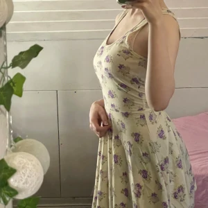 Blommig klänning - SHEIN - En söt och fin klänning i en off-white färg och lila blommor. Lite öppen i ryggen. Otroligt mjuk och skön att ha på sommaren. Det står att det är storlek S men passar mig som har storlek XS. Använd ett fåtal gånger💕