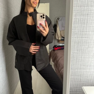 Svart skinnjacka med ståkrage - Skitsnygg skinnjacka från nakd. Helt oanvänd! Passar till många olika outfits och är ett måste i garderoben.