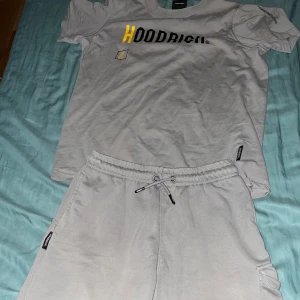 Grå shorts från Hoodrich med snörning - Snygga grå shorts från Hoodrich med elastisk midja och snörning. Shortsen har fickor på sidorna och en extra ficka med lock på ena benet. Hoodrich-logga i svart och gult tryck på benet.