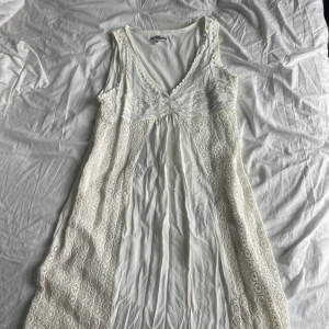 Vit spetsklänning från My Collection - Perfekt för sommarens studentfester!!!Romantisk vit långklänning från My Collection, gjord i Paris. Den är mjuk men håller formen. Dragkedja finns på sidan och klänningen är mid-thigh lång.