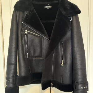Svart skinnjacka med pälsdetaljer från Missguided - Säljer en svart skinnjacka från Missguided med mjuka pälsdetaljer på krage och insida. Använd väldigt få gånger och har inga märken på användning.