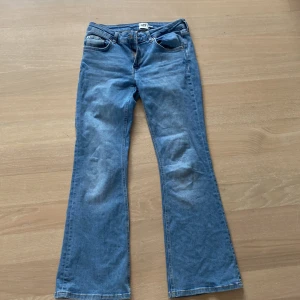 Blå bootcut jeans från 157 - Säljer ett par klassiska blå bootcut jeans från 157 med låg midja. Jeansen har fem fickor och är tillverkade i denim. Perfekta för dig som gillar en retroinspirerad look med utsvängda ben. I storleken M short