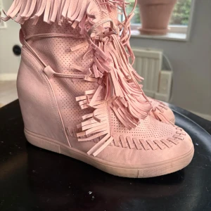 Rosa kilklack med fransar  - Säljer ett par unika rosa sneakers med kilklack och massor av fransdetaljer. Skorna har snörning framtill och perforerade partier för extra stil. Ena snöret har gått sönder men fixat så de funkar och syns inte när man har på dem❤️
