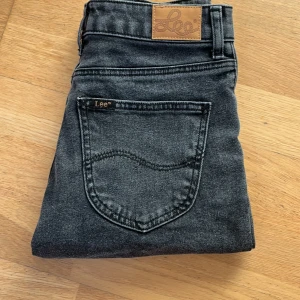 Svarta jeansshorts från Lee - Snygga svarta jeansshorts från Lee med klassisk femficksdesign och hög midja. Shortsen har Lee-logga på bakfickan och läderpatch bak i midjan. Perfekta för en avslappnad stil och passar till det mesta. Passar xs-s
