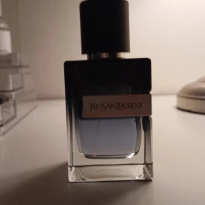 Yves Saint Laurent Eau de Parfum, byten funkar bra! - Elegant parfym från Yves Saint Laurent i en stilren flaska med mörk överdel och transparent botten. Doften är intensiv och sofistikerad, perfekt för den som vill ha något extra. Flaskan rymmer 60 ml och har en modern design som passar in i alla miljöer.