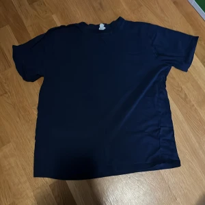 Mörkblå t-shirt från Time to Lounge - En enkel och stilren mörkblå t-shirt från Time to Lounge. T-shirten har en klassisk passform med rund halsringning och korta ärmar. Perfekt för en avslappnad look.