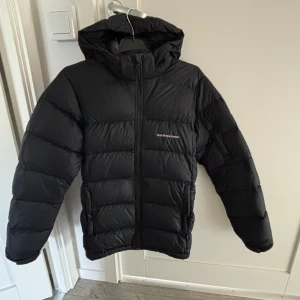 Svart dunjacka från Peak Performance - Säljer en svart dunjacka från Peak Performance. Mycket väl använd (bla. några defekter och något tunnare än en ny) därav det väldigt billiga priset. Storlek 170, passar även du som bär S/M