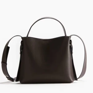 Brun axelväska  - Säljer en stilren brun axelväska i skinn med både kort handtag och justerbar bred axelrem. Väskan har minimalistisk design och stängs med magnetknapp. Perfekt för dig som vill ha en snygg och praktisk accessoar till vardagen.