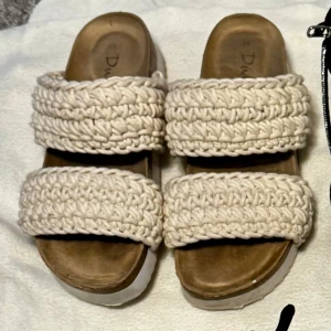 Beige stickade sandaler med plattform - Säljer ett par beige sandaler med breda stickade band och plattformsula. De har öppen tå och en chunky look som passar perfekt till sommarens chill outfits. OBS skon ser smutsigare ut med detta ljus samt med skuggan men dessa skor är typ oanvända 