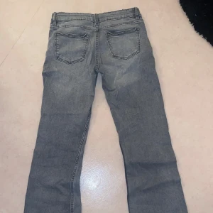 Grå jeans från Gina Tricot, stl 158 - Säljer ett par grå jeans från Gina Tricot i storlek 158. Jeansen har klassisk femficksdesign, knäppning med knappar och raka ben. Snygg tvättad grå färg som passar till det mesta. Perfekta för dig som gillar en enkel och stilren look.