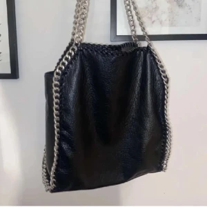Tiamo väska  - Säljer en snygg tiamo väska köpt på scorett i storlek L och mycket fint skick! Perfekt för dig som gillar en edgy stil och vill ha plats för mycket. Nypris: 599kr