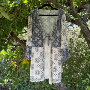 Vit och grå mönstrad kofta - Supersöt kofta från Odd Molly med bohemisk känsla. Koftan är vit och grå med blandade mönster, har v-ringning med snörning framtill och långa ärmar. Volangdetaljer och ljusgrön kant ger extra charm. Perfekt för dig som gillar unika prints och avslappnad stil. Storlek 3 som enligt deras storleksguide motsvarar en storlek L.  Mycket fint skick, jag hittar inga synliga anmärkningar eller defekter. 