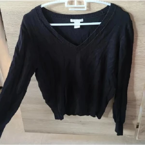 V-ringad svart tröja från HM - Säljer en svart tröja från HM basic med V-ringning. Tajtare vid handleder och midja, bra skick.