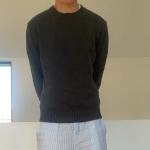 Ralph Lauren Mörkgrå tröja - Säljer en galet fet stickad tröja från Ralph Lauren. Tröjan är i en mörkgrå färg som om väldigt populär just nu då de passar till typ allt!! Tröjan har även så ribbade ärmar vilket är ett måste på en stickad tröja! Den är i bra skick och hör gärna av er vid frågor eller funderingar!!