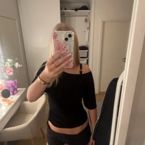 Svart offshoulder topp från lager 157 - Säljer en svart offshoulder topp med tight passform och korta ärmar. Toppen har snygg rynkdetalj på sidan och är tillverkad i ett stretchigt material som sitter skönt mot kroppen. Använd fåtal gånger, passar väldigt bra till jeans eller shorts❣️❣️