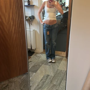 Blå bootcut jeans från 7 for All Mankind - Snygga blå jeans från 7 for All Mankind i klassisk bootcut-modell med låg midja. Perfekt passform som ger en avslappnad men ändå trendig vibe. Säljer för att de var lite för stora för mig i midjan. Helt oanvända (av mig men köpte av sellpy) och i jättebra skick!