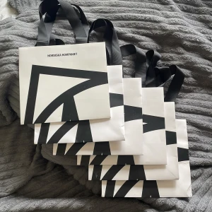 Shoppingväska Nordiska Kompaniet - Säljer flera shoppingväskor från Nordiska Kompaniet i vitt med svart grafiskt tryck och breda svarta handtag. Perfekt för att bära med sig grejer till stan eller skolan. Stilren design som sticker ut och känns lyxig.