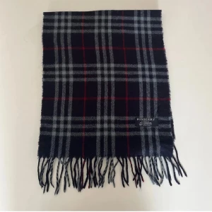 Rutig kashmirhalsduk från Burberry - Burberry halsduk i utmärkt skick, inga tecken på användning! Skick: 9/10, använd ett fåtal gånger förra vintern! Den är i 100% kashmir. Ordinarie pris: 4000 kronor. Vid eventuella frågor eller funderingar är det bara att höra av sig. Pris kan diskuteras! 