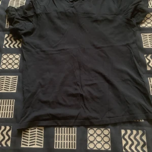 Svart t-shirt från Take Off - En basic svart t-shirt från Take Off i storlek S. T-shirten har rund halsringning och korta ärmar, perfekt för en clean och enkel stil. Tillverkad i mjuk bomull som känns skön mot huden. Passar dig som gillar minimalistiska plagg.