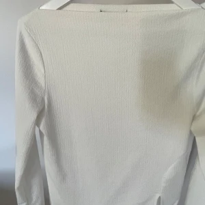 Vit topp från Gina Tricot  - Vit topp från Gina Tricot, med boat neck och slits nedtill. I strlk S