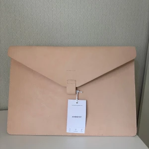 Beige datorväska i skinn från Sandqvist - laptopfodral som passar 13" laptops. tillverkad av anilinfärgat skandinaviskt full-grain läder.  B 36 x H 25,5 100% äkta läder aldrig använd, ursprungspris 1500kr