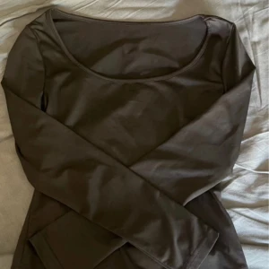 Svart  långärmad topp - En stilren mörkbrun långärmad topp med rundad halsringning. Enkel och clean design som passar perfekt till jeans eller kjol. Tillverkad i mjukt material som känns skönt mot huden.