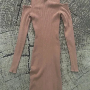 Ribbad beige offshoulder klänning H&M - Skick: Bra Storlek: Xs Material: bomull Märke: H&MSupersnygg ribbad beige klänning från H&M                                                                     i storlek XS. Modellen är långärmad med offshoulder-detalj och har en kroppsnära passform. Perfekt för dig som gillar stilrena och trendiga plagg med lite edge. Materialet är mjukt och stretchigt för en skön känsla.