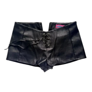 Edikted skinnshorts med snörning - Coola svarta shorts i skinnmaterial med låg midja och snörning framtill. Så coola med dragkedja baktill, midjemått 34 cm tvärsöver 💕
