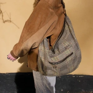 Rutig axelväska  - Snygg rutig axelväska med praktisk dragkedja framtill. Väskan har en bekväm axelrem och är perfekt för att bära dina dagliga nödvändigheter.