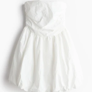 Vit axelbandslös klänning - Super fin klänning som passar perfekt till studenten. Aldrig använd men har sytt dit en dragkedja så att den lättare går att ta på utan att få smink på. Bilderna är lånade så skriv för egna😊