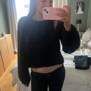 Svart fluffig tröja - Säljer en svart fluffig tröja med lång ärm och croppad passform. Perfekt för en mysig och stilren look. Tröjan har en unik textur som ger extra värme och komfort. 🎀🎀🎀