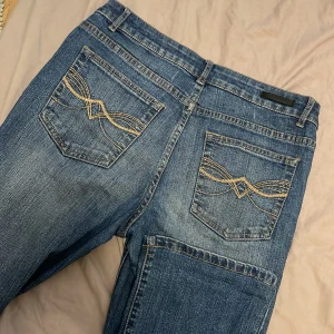 Blå jeans från b.young - Snygga blå jeans från b.young med dekorativa sömmar på bakfickorna. Klassisk femficksdesign med knapp och dragkedja framtill. Perfekta för en avslappnad stil. 73 innerben 38-39 midjemått straight/oversize fit lite baggy priser kan alltid diskuteras 