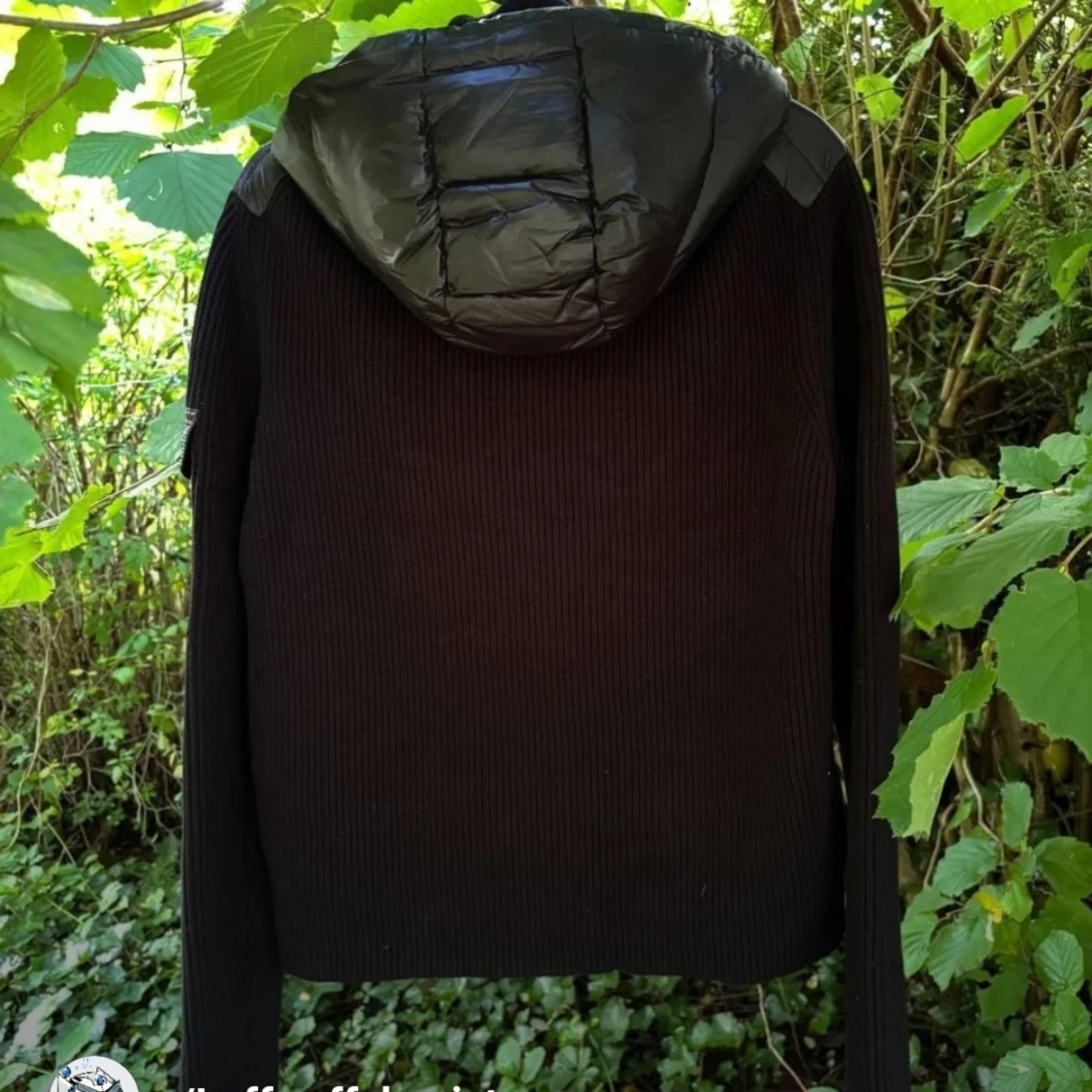 Svart pufferjacka med stickade ärmar