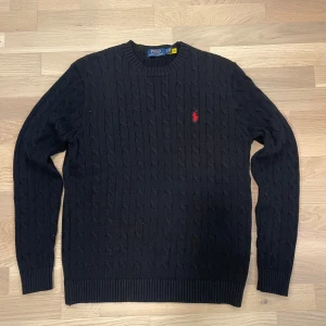 Svart stickad tröja från Polo Ralph Lauren - Säljer en stilren svart kabelstickad tröja från ralph Lauren, 10/10 skick som passar till allt. Tröjan är i storlek S och kommer till 100% ge dig massor av komplimanger. 