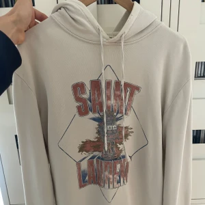 Saint Laurent Hoodie  - Säljer denna sjukt snygga och trendiga ysl hoodien ! Otroligt bra skick! (Hålen är en del av designen). Storlek S / 175 men är stor i storleken, sitter bra på mig som är runt 185. Vid frågor är det bara att höra av sig ! Allt gott.