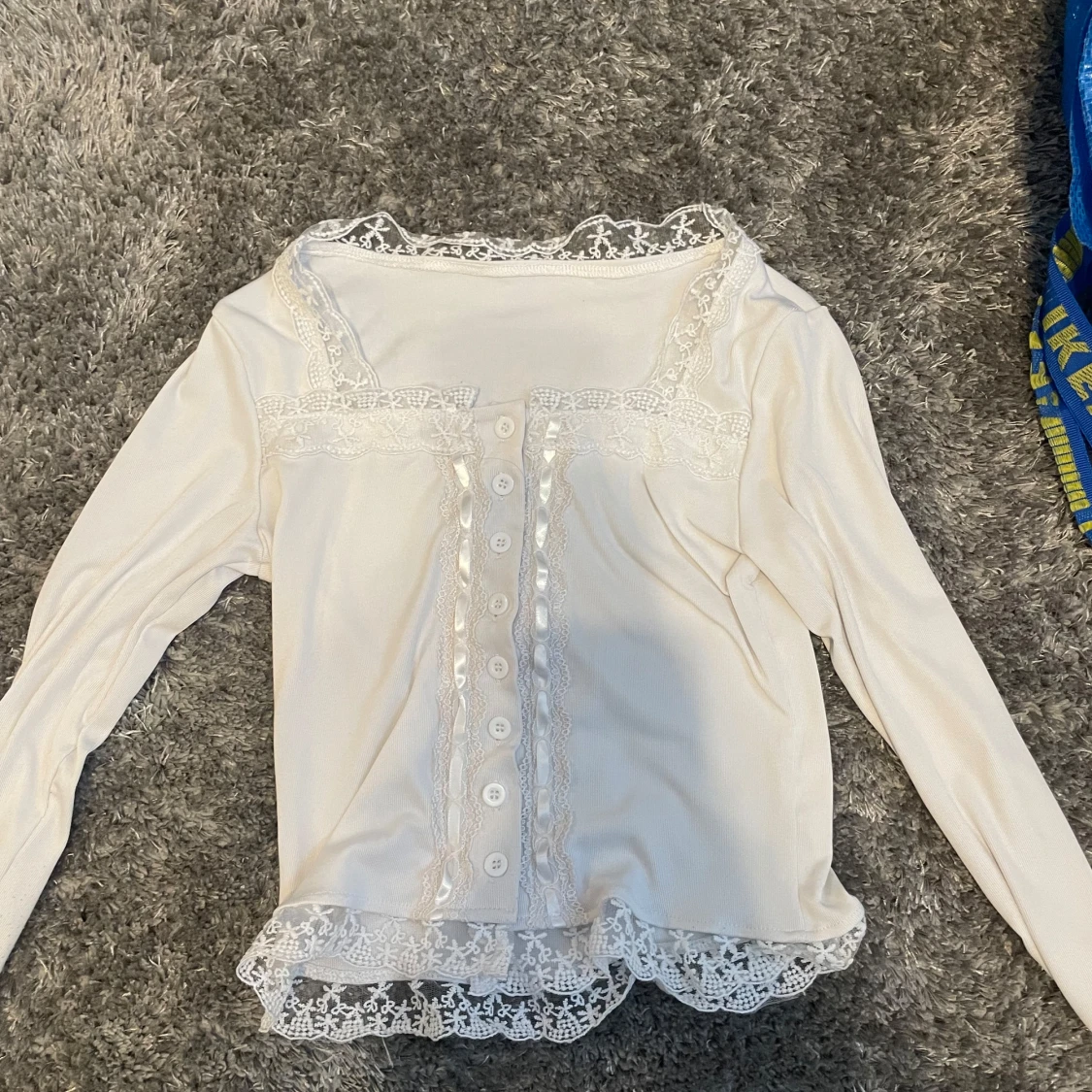 Vit långärmad topp med spetsdetaljer