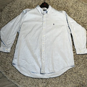 Ralph Lauren skjorta (Nyskick) Inte såld!! - Säljer just nu en ljusblå skjorta från Ralph Lauren med broderad logga på bröstet. Skjortan har långa ärmar och knappar framtill. Perfekt för en stilren look. Ny pris va typ ungefär 1500kr och den är i väldigt fint skick. Det är en storlek 17 vilket motsvarar ungefär XL. Säljer samtidigt andra skjortor av samma kvalitet och stilar finns på min sida! Hör av er vid frågor.                           MVH: Wilmer