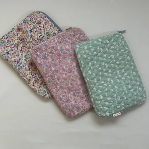 Blommiga quiltade datorväskor - Säljer tre quiltade datorväskor med blommigt mönster. En är grön med vita blommor, en rosa med små blommor i olika färger, och en vit med ett färgglatt blommönster. Alla har dragkedja för säker förvaring. Perfekt för att ge din laptop ett stilfullt skydd! 99kr per datorfodral 🤍🤍🤍