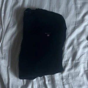 Svart stickad tröja från GANT - Klassisk svart stickad tröja från GANT i storlek S. Tröjan är köpt för runt 1200 på NK säljes för 299